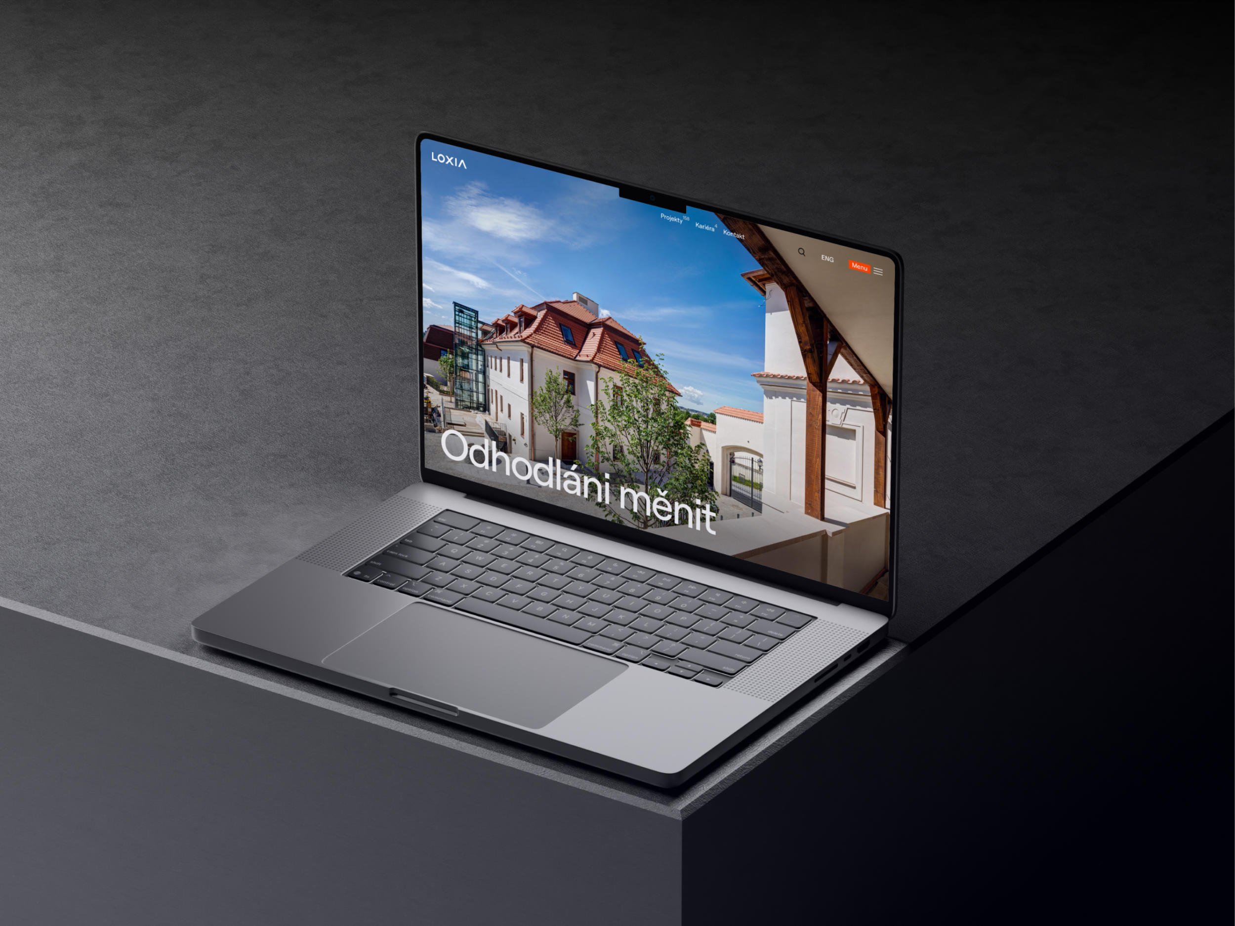 Otevřený notebook na tmavém stole s moderní architekturou na obrazovce představující inspiraci a kreativitu při práci v kanceláři nebo doma pro efektivní práci.