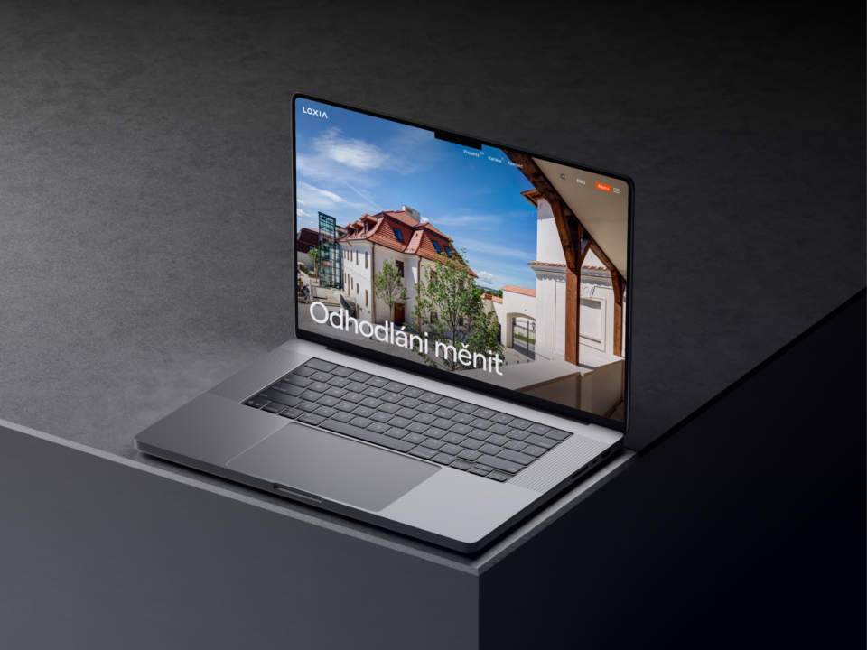 Otevřený notebook na tmavém stole s moderní architekturou na obrazovce představující inspiraci a kreativitu při práci v kanceláři nebo doma pro efektivní práci.