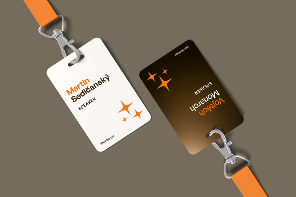 Two upside-down name tags on a gray background with orange details and a logo. One tag is white with the text "Martin Sedlanský" and the other is dark with the text "Vlasák Montero.".