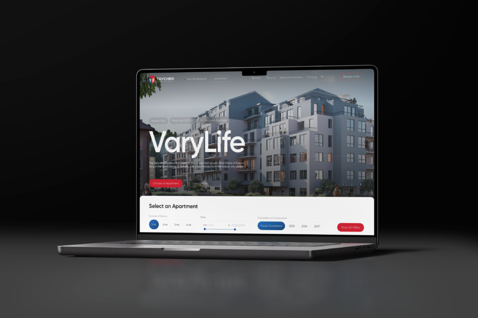 A modern laptop with a webpage open for VaryLife, a real estate company specializing in luxury apartments. A large residential complex is displayed on the screen.
