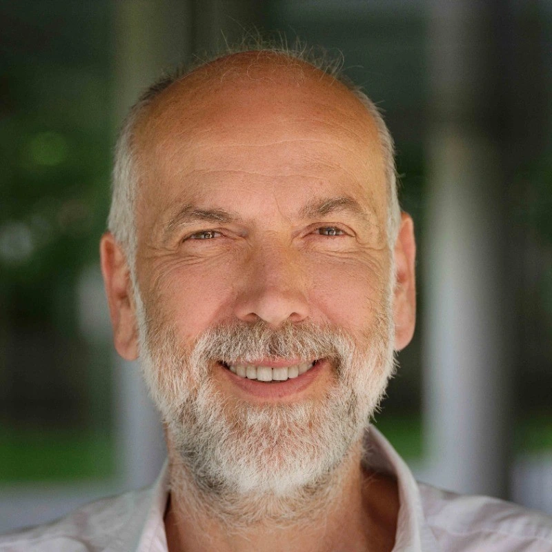 Older man with a smile and grey hair in a natural environment