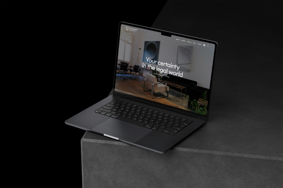 An open laptop on a dark background displays a web page with the text "Your Assurance in the Legal World." A modern and elegant design featuring technology and digital content.