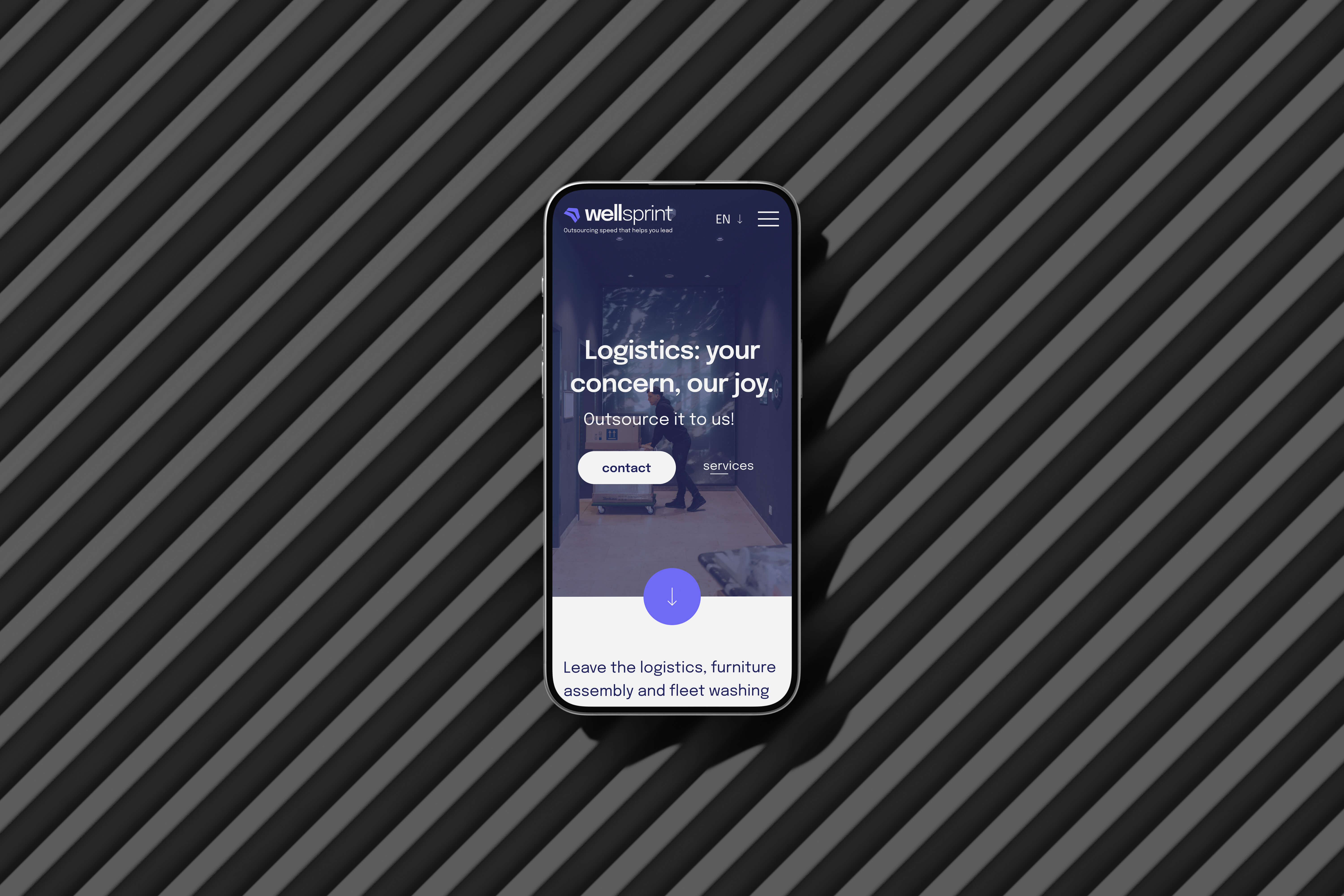 Chytrý telefon zobrazující webové stránky Wellsprint s textem Logistika: vaše starost, naše radost na tmavém pozadí, umístěný na černém diagonálně pruhovaném povrchu.