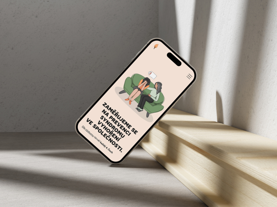 Smartphone opřený o zeď zobrazuje ilustraci dvou lidí na pohovce a text zaměřující se na prevenci výrobních chyb a na zlepšení provozních postupů ve společnosti.