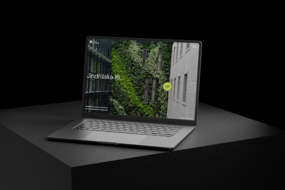 A laptop with the Jindřišská 16 website and the building's green facade against a dark background