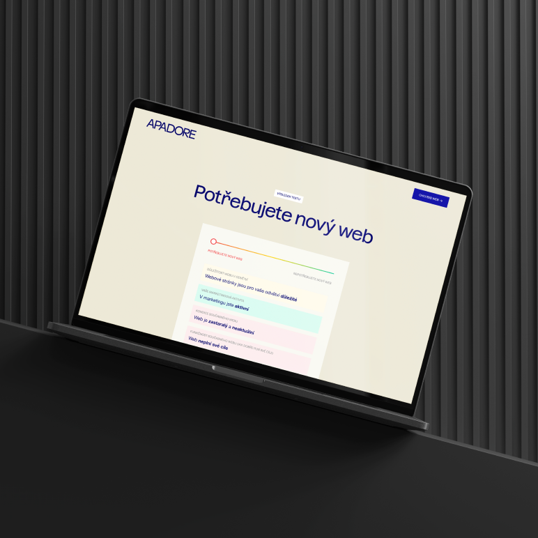 Notebook na černém stole s otevřenou webovou stránkou s nápisem Potřebujete nový web na obrazovce v moderním a minimalistickém designu na šedém pozadí.