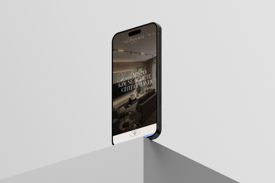 A modern cell phone resting on its edge, displaying a webpage featuring a luxurious interior design with an elegant interior and subdued lighting in a stylish design